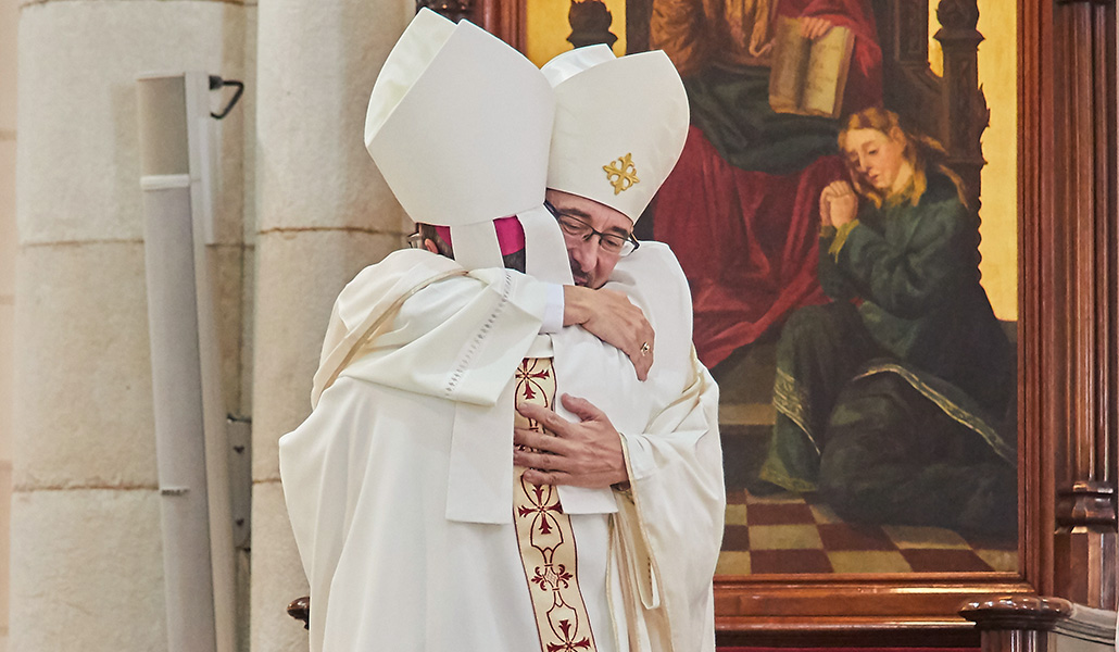 El nuevo arzobispo abraza a su hermano en el episcopado auxiliar de Madrid, Jesús Vidal, durante la Misa