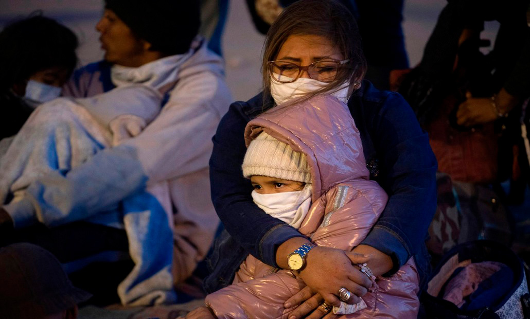 Una madre abraza a su hija mientras esperan en un centro de detención para migrantes