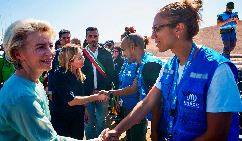 La presidenta de la Comisión Europea, Ursula von der Leyen y la primera ministra Giorgia Meloni saludando a los miembros del Alto Comisionado de las Naciones Unidas para los Refugiados (ACNUR) durante su visita a la isla italiana de Lampedusa, el pasado domingo 17 de septiembre