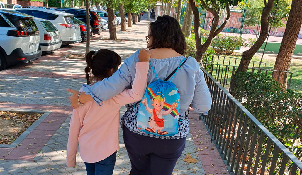 Niña tutelada con una mujer, de espaldas