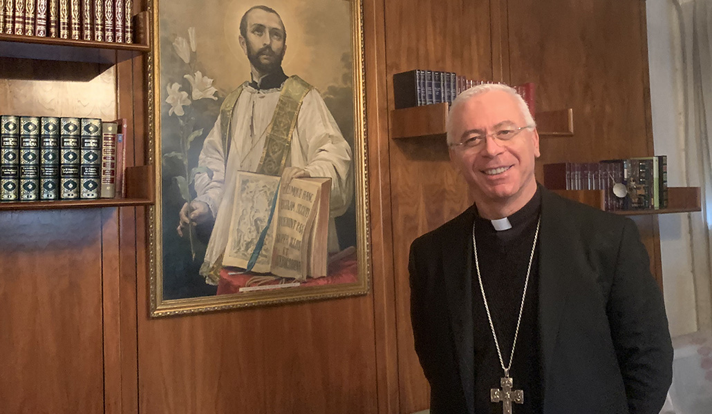 Peragine, obispo de Albania, delante de un cuadro del fundador de su congregación