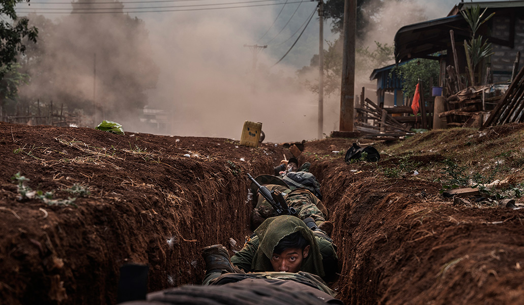 Combatientes de la KNDF se protegen en una zanja de una explosión