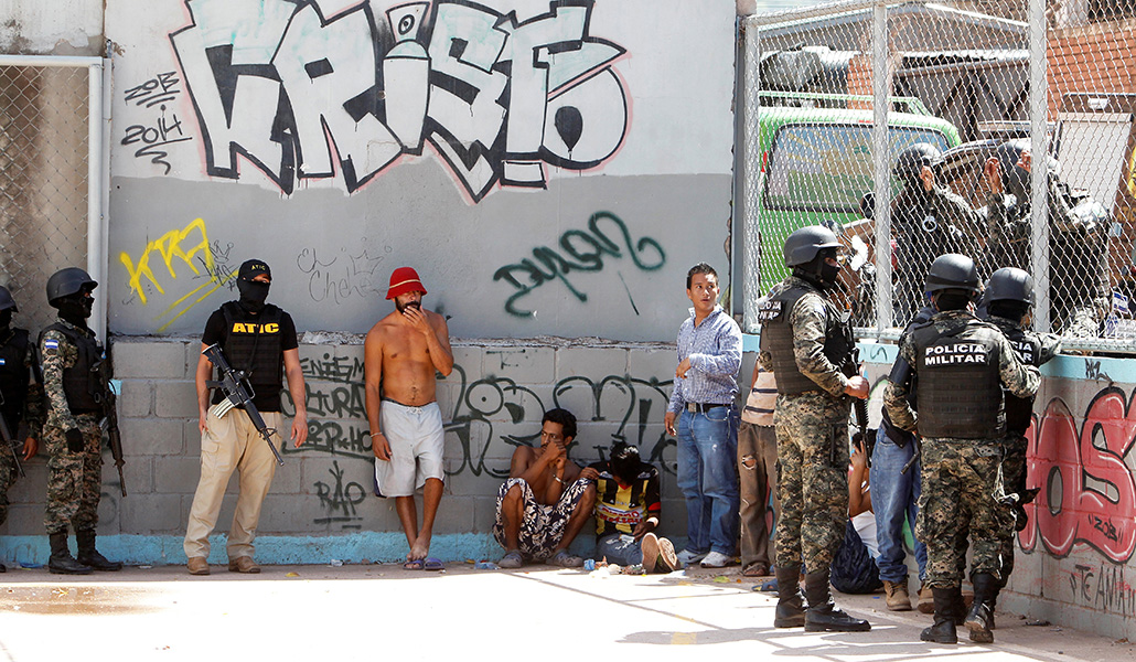Policías militares en Tegucigalpa (Honduras) vigilan a presuntos pandilleros de la MS-13