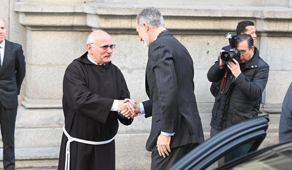 El rey saluda a un fraile capuchino en el exterior de la basílica de Jesús de Medinaceli