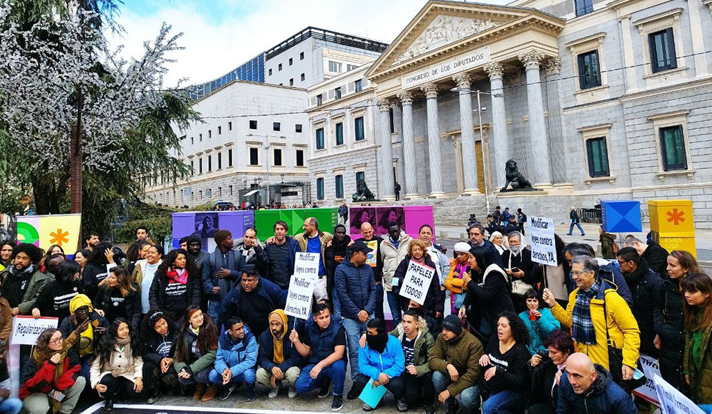 Miembro de la plataforma Esenciales frente al Congreso de los Diputados pidiendo al regulaziación de la ILP