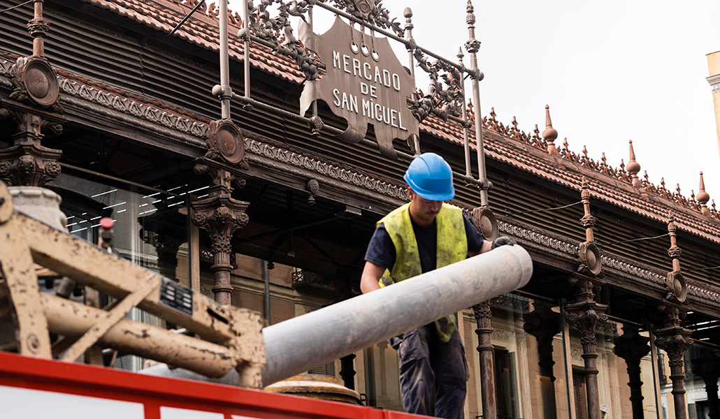 Un obrero realiza labores de construcción frente el Mercado de San Miguel, en Madrid