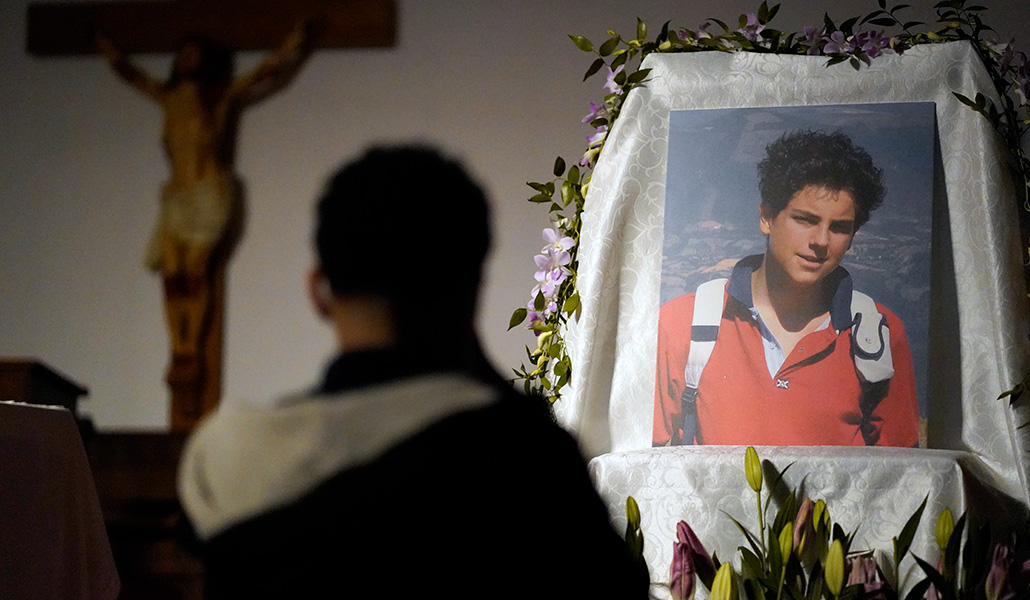 Un niño en oración ante una imagen del beato Carlo Acutis en Nueva York (Estados Unidos)