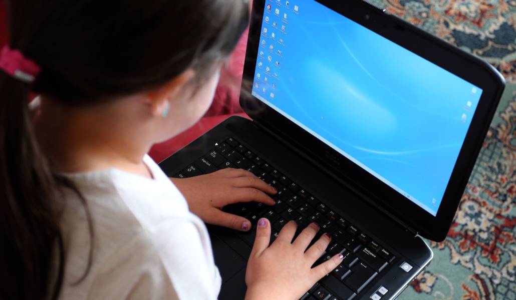 Una niña utilizando un ordenador portátil