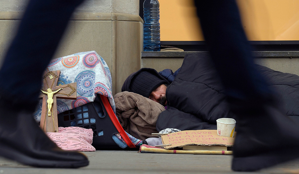 Un hombre duerme en el Paseo de Gracia de Barcelona