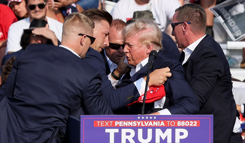 El candidato presidencial republicano Donald Trump, es asistido por guardias tras recibir varios disparos en el Butler Farm Show en Pensilvania