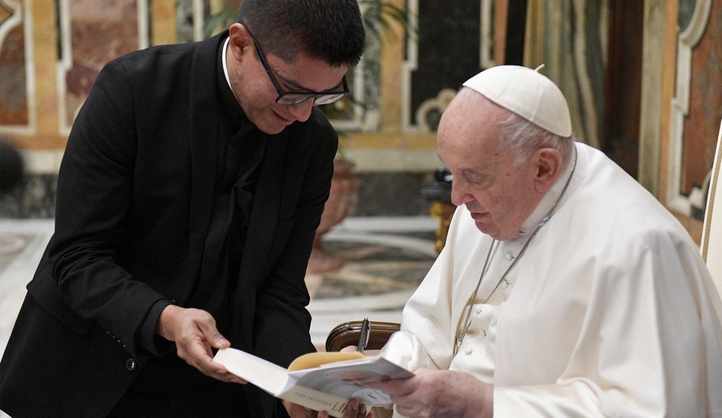 El Papa firma un ejemplar de su autobiografía durante un encuentro con jóvenes sacerdotes latinoamericanos