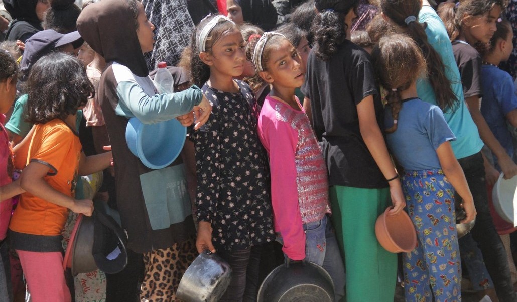 Niñas esperan para recibir una ración de comida en Jabalia
