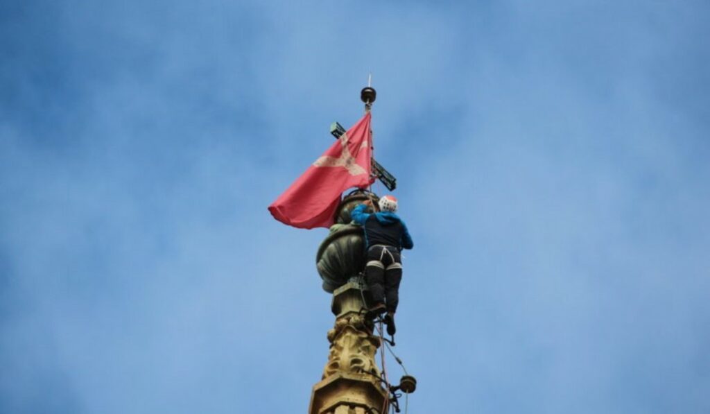 Colocación de una de las cinco banderas en la torre de la catedral