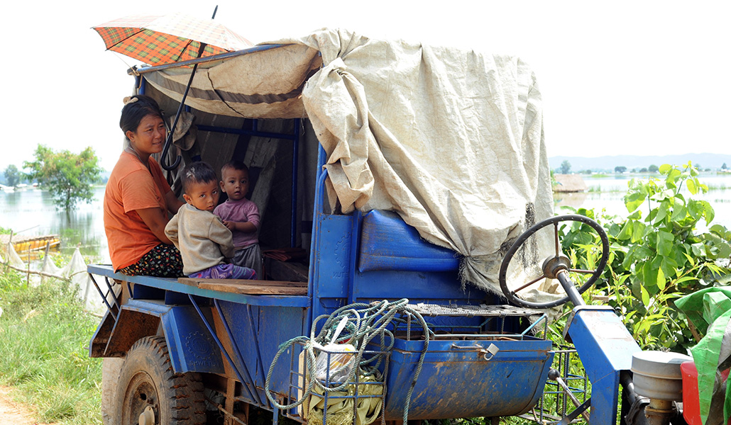 Una mujer y sus hijos, afectados por las inundaciones, en el campamento de desplazados internos de Naung Khaing, en Loikaw (estado de Kayah)