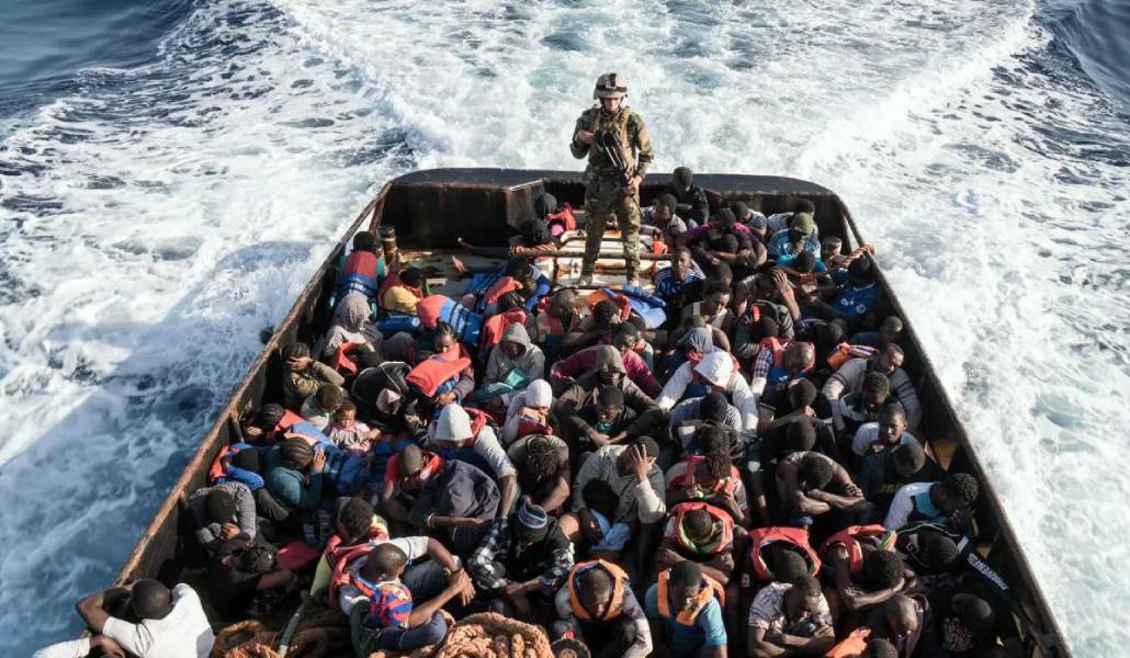 Un guardacostas libio, en pie, en un bote durante el rescate de 147 migrantes que se dirigían a Europa