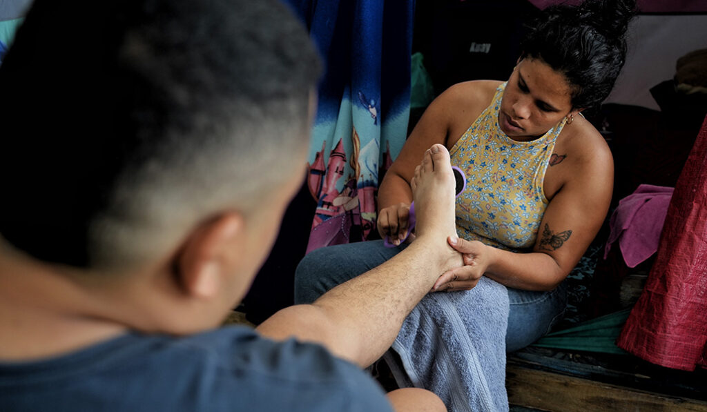 Carmen atiende las heridas que ha sufrido en los pies su marido, José, tras viajar desde Venezuela
