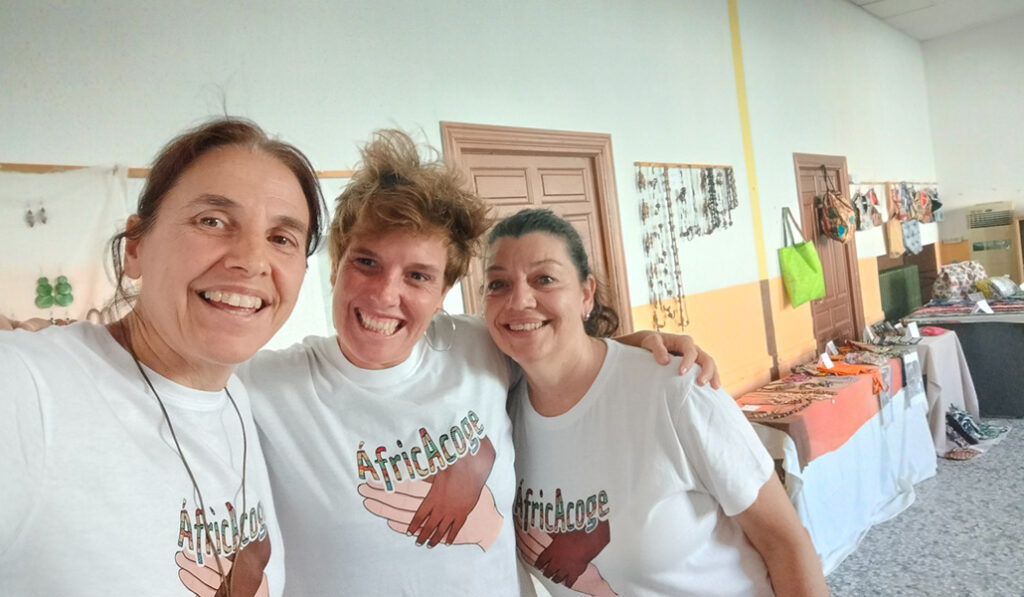 María Escarda (izq.), Ana Campo (centro) y Miriam Iglesia (dcha.) este verano durante el mercadillo solidario