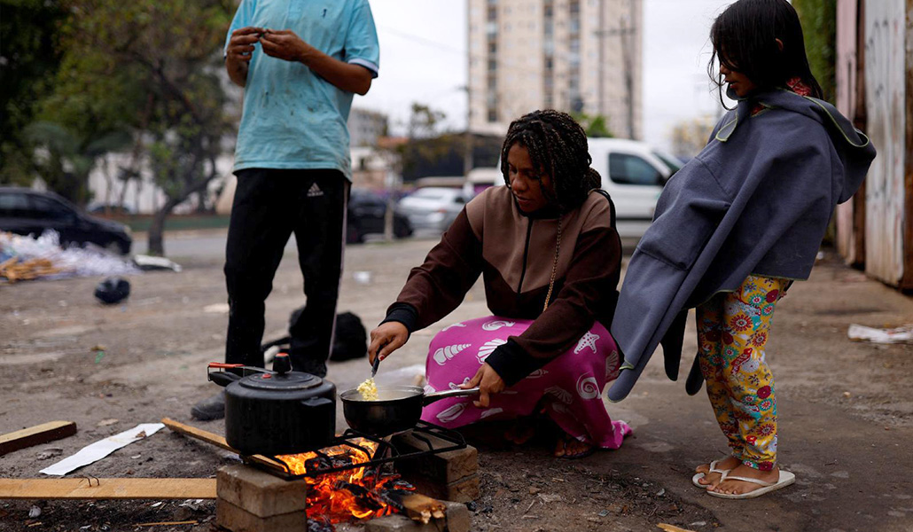 Una mujer sin hogar cocina para su familia en una calle de Sao Paulo, en Brasil