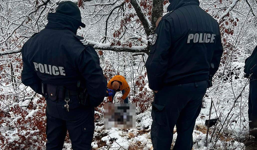 Agentes de la Policía miran cómo otro, sin uniforme, inspecciona el cadáver de Ahmed Samra
