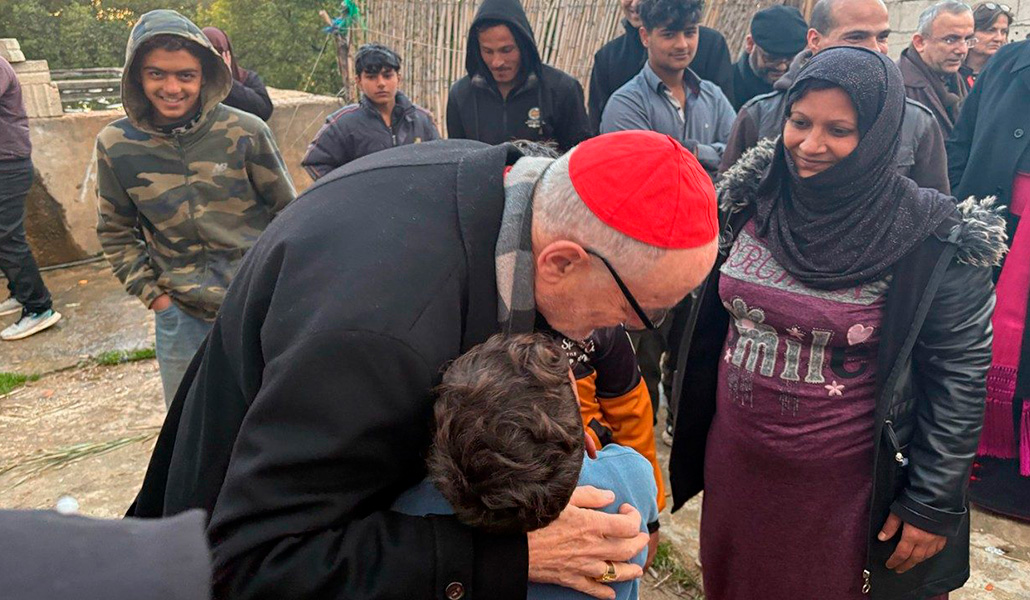 El cardenal Michael Czerny abraza a un niño en el campo 004