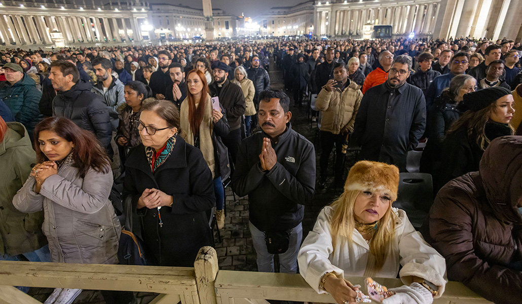 Fieles rezan el pasado lunes en la plaza de San Pedro, poco después de que el Vaticano anunciara una «leve mejoría»