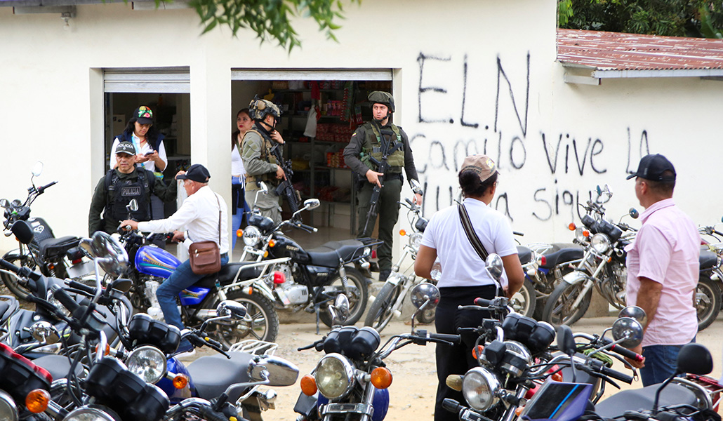 Miembros de las fuerzas de seguridad montan guardia mientras la caravana humanitaria se reúne con los habitantes de El Tarra