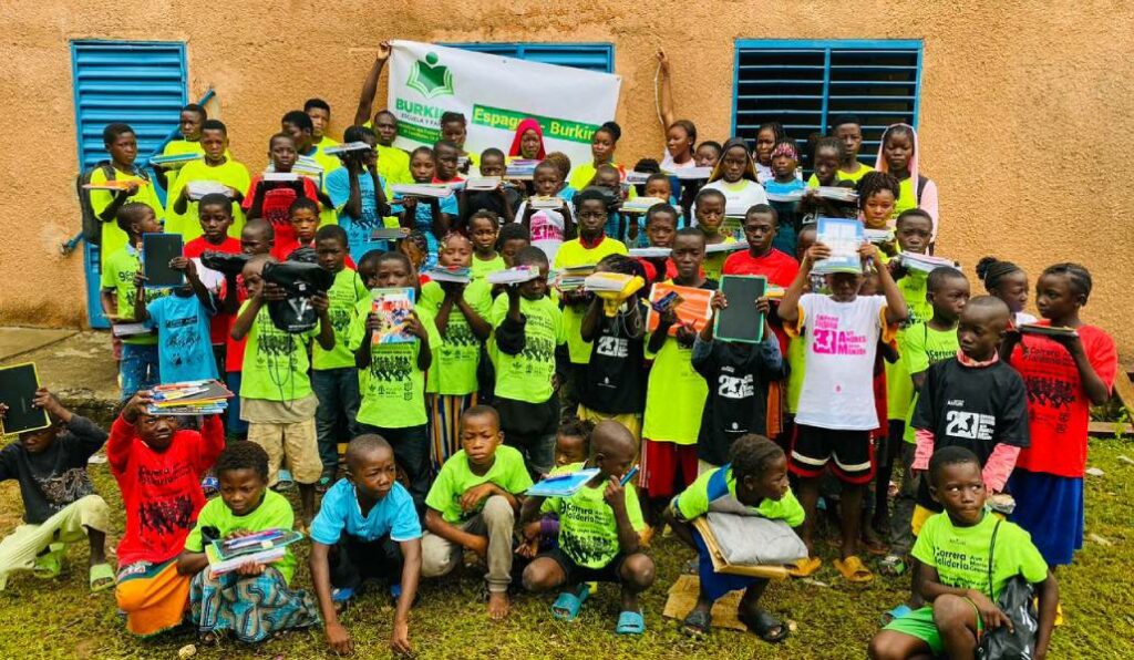 Los niños de la aldea de Zabré, en Burkina Faso, reciben el último cargamento con material escolar enviado en septiembre