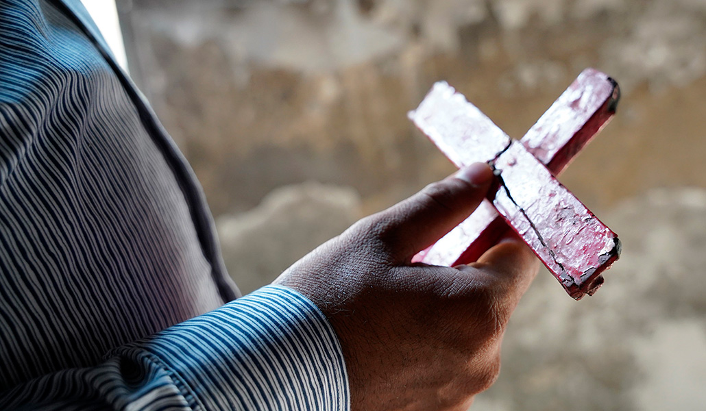 Un cristiano pakistání sujeta una cruz