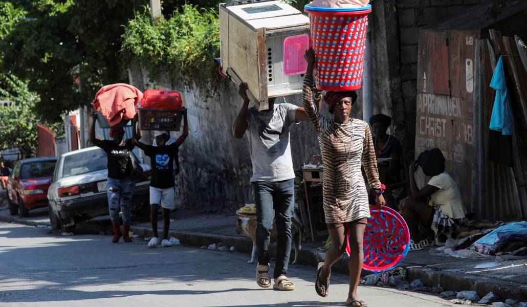 Haitianos huyen de la violencia callejera con sus pertenencias a cuestas en Puerto Príncipe