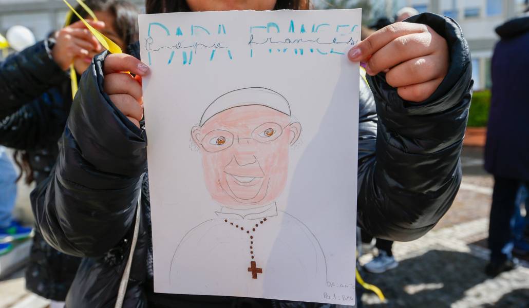 Una niña sostiene un dibujo del Papa a las afueras del hospital Gemelli de Roma