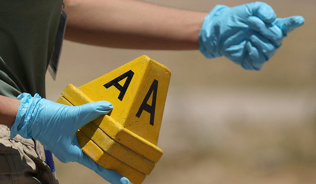 Un técnico forense colocando balizas