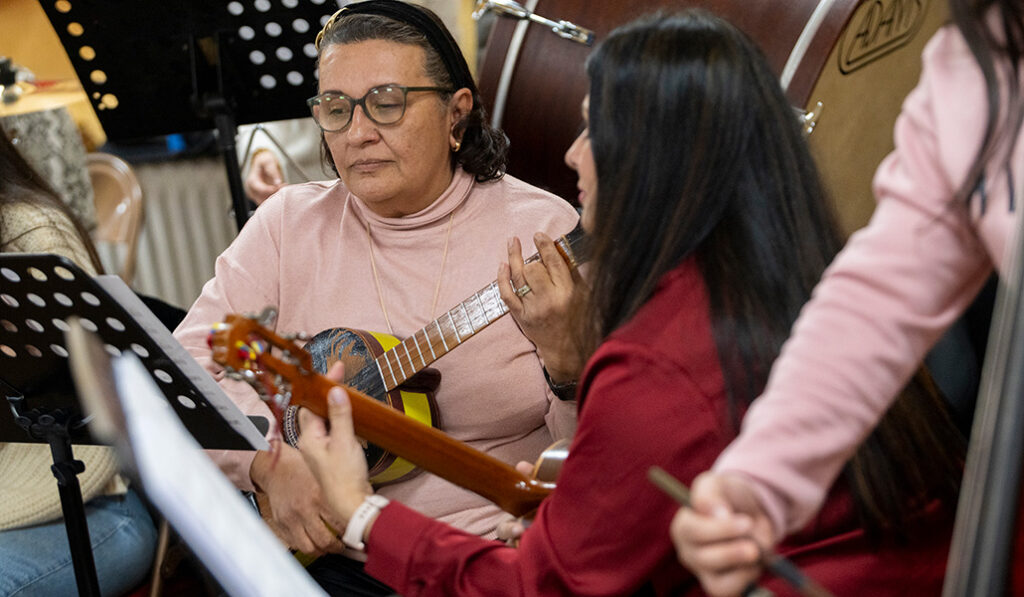 Hurtado (rojo) toca el cuatro con una compañera