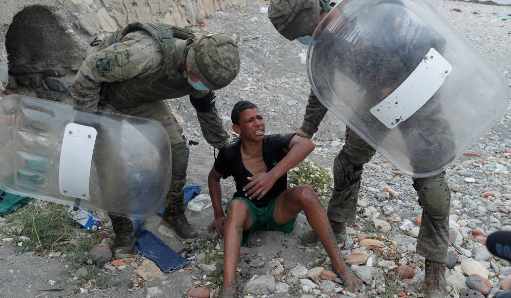 Militares españoles recogen a un migrante en la playa de El Tarajal en 2021
