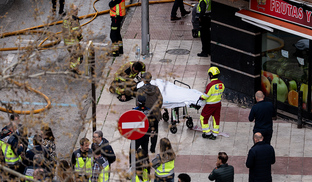 Un bombero arrodillado ante el cuerpo de su compañero fallecido