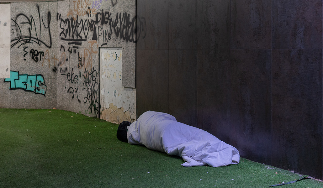 Una persona duerme en la zona comercial de Azca, en Madrid