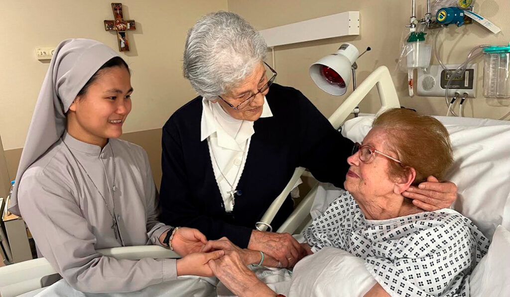 Sor Regina, en el centro, atiende a enfermos en el Hospital Beata María Ana