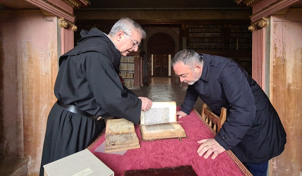 El novelista mira algunos libros que custodian los agustinos recoletos en San Millán de la Cogolla.