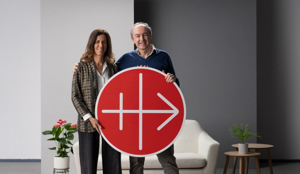 Dos personas, mujer y hombre, posan con el logo de ACN.