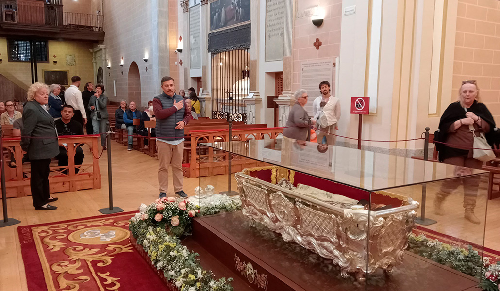 Un peregrino hace la señal de la cruz ante el cuerpo de santa Teresa.