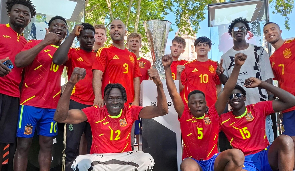La Selección Española de Refugiados posa con el trofeo de la UEFA Europa League tras disputar el partido por la inclusión en Bilbao