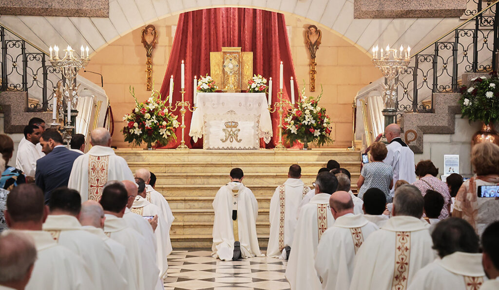 Los fieles adoran la Eucaristía durante la procesión dentro de la Almudena