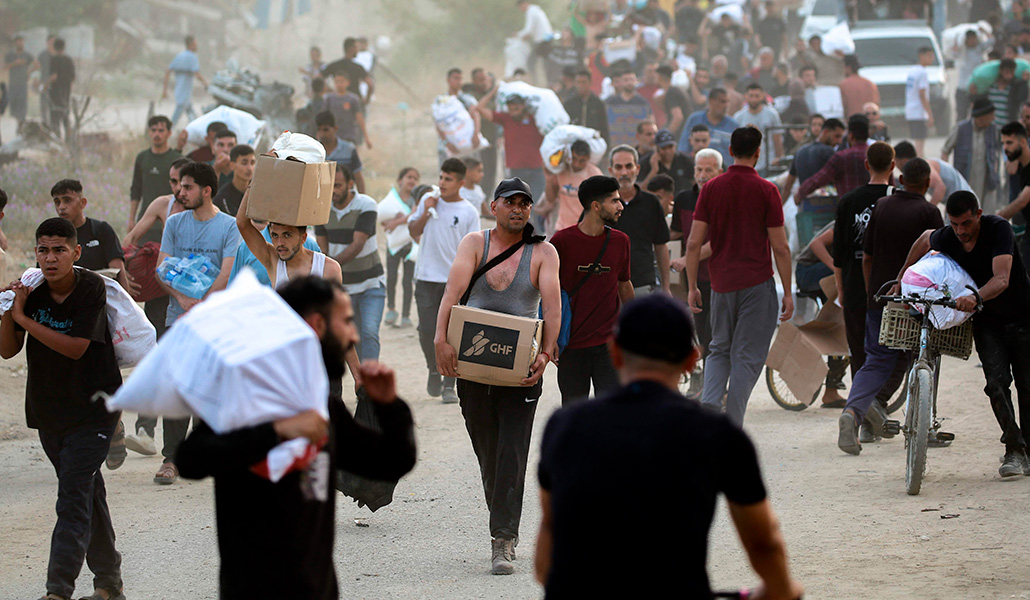 Palestinos regresan de un reparto de alimentos de la GHF, el 8 de junio