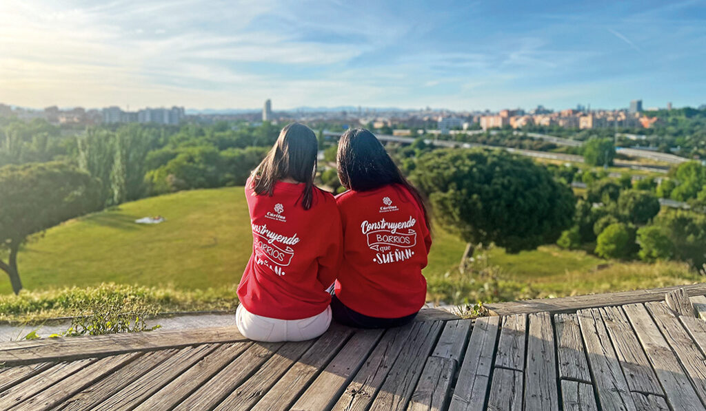 Dos voluntarias de Cáritas observan el horizonte desde los barrios periféricos de Madrid