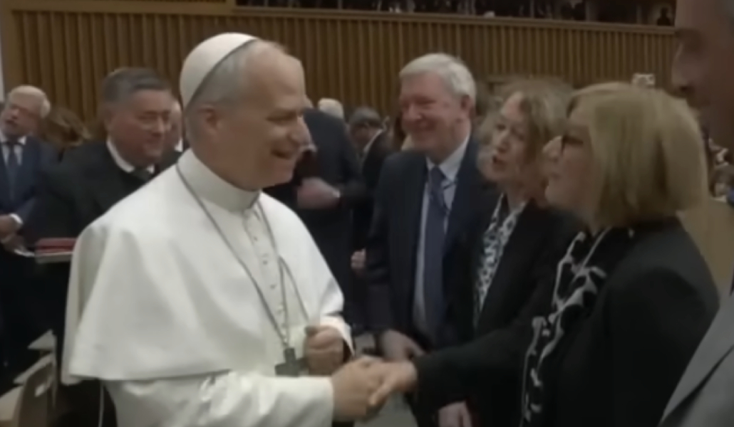 Eva Fernández, a la derecha, da la mano a León XIV en su encuentro con periodistas el 12 de mayo