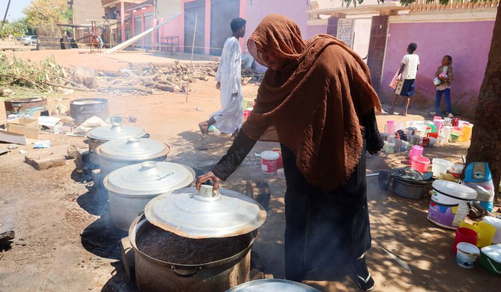 Una mujer prepara comida en un campo de desplazados de Sudán