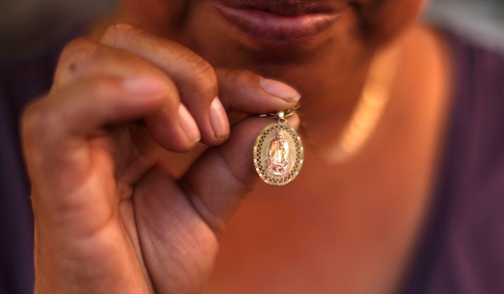 Una mujer de California muestra la medalla de la Virgen de Guadalupe que espera que la proteja de las redadas.