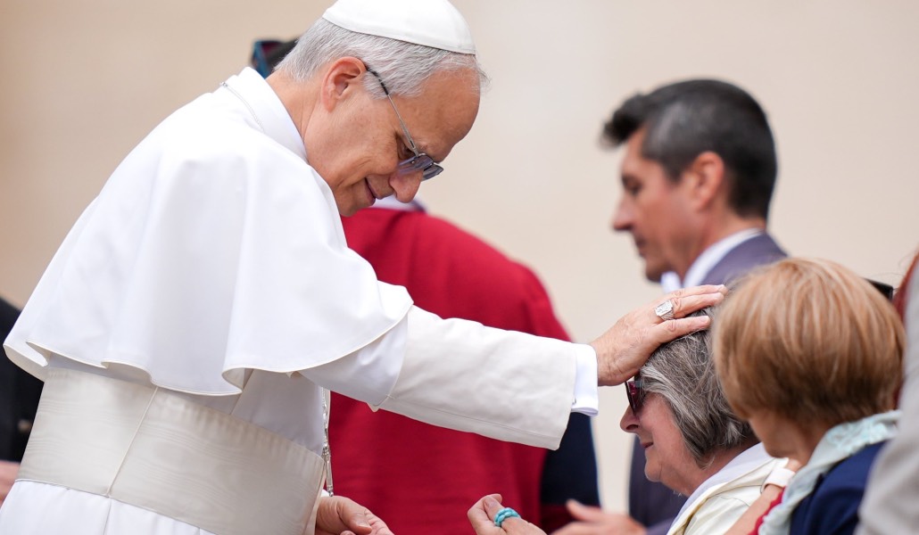 El Santo Padre bendice a una mujer mayor durante su primera audiencia general.