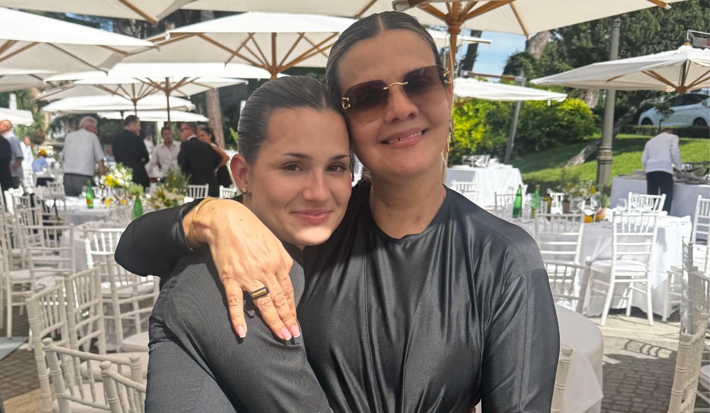 Valeria junto con su madre, ambas vestidas de negro, con la madre con el brazo echado sobre la joven, sonrientes