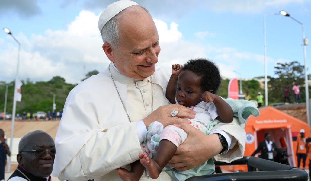 León XIV abraza a un bebé en el santuario de Mama Muxima, en Angola.