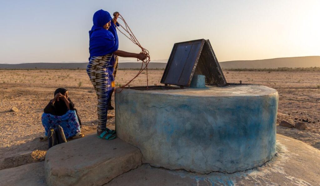 Esta madre somalí saca agua de un pozo.